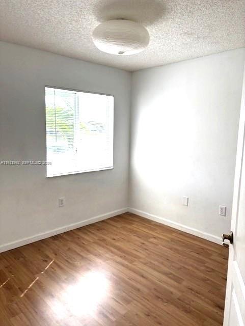 14045 Southwest 121st Place, Unit 524 Miami, FL 33186 - Photo 38 of 46 an empty room with wooden floor and windows