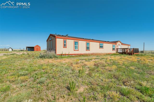 6240 Night Train Lane Yoder, CO 80864 - Photo 3 of 50 Rear view of house with an outdoor structure and a deck