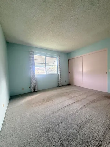 an empty room with windows and closet