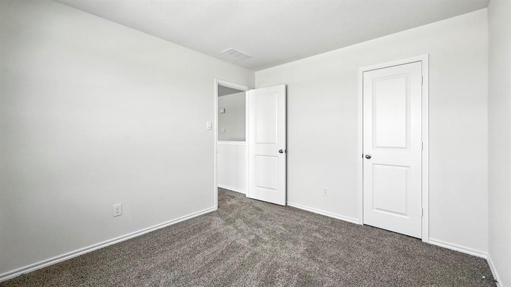 122 Pheasant Run Road Terrell, TX 75160 - Photo 16 of 36 Neutral gray wall paint with white trim, gray patterned carpet, and two white paneled doors