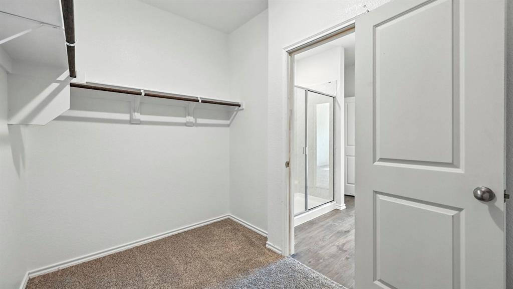 122 Pheasant Run Road Terrell, TX 75160 - Photo 18 of 36 Walk-in closet featuring carpet flooring, built-in shelving, and a hanging rod