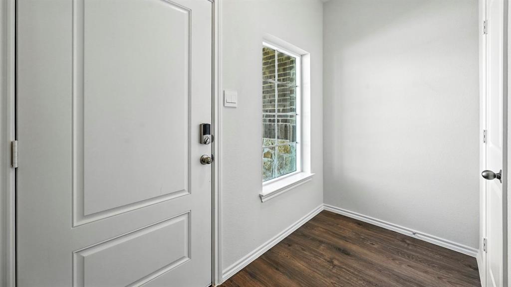 122 Pheasant Run Road Terrell, TX 75160 - Photo 20 of 36 Entryway featuring a white paneled door with smart lock hardware, wood-finish flooring, white baseboards, and a window with natural light