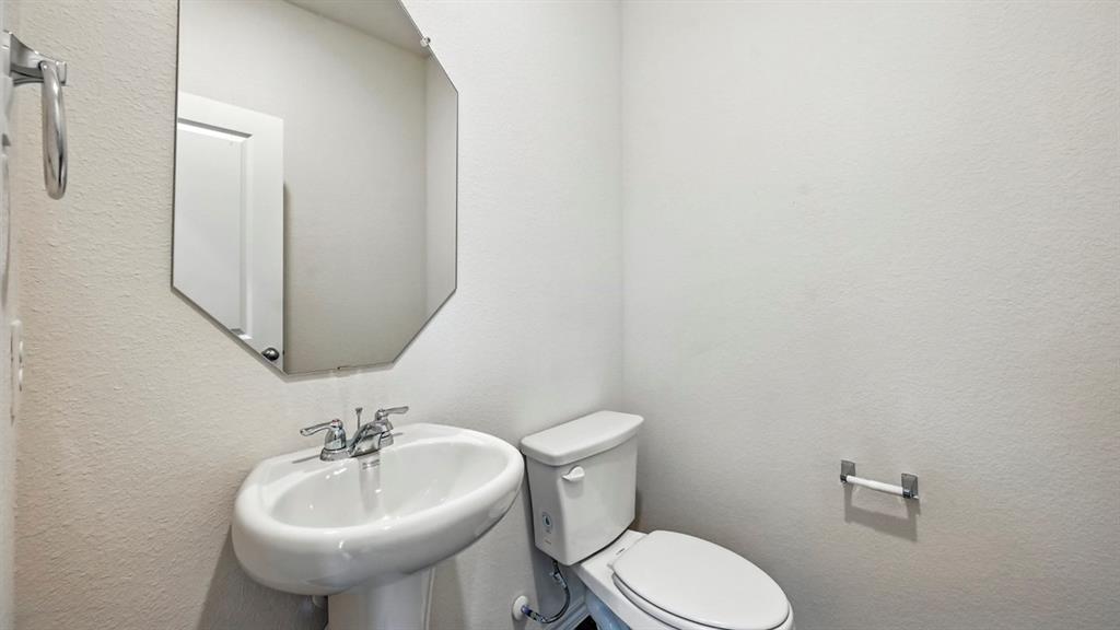 122 Pheasant Run Road Terrell, TX 75160 - Photo 27 of 36 Pedestal sink with chrome fixtures and an octagonal mirror