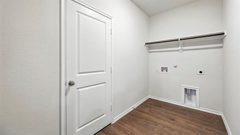 122 Pheasant Run Road Terrell, TX 75160 - Photo 33 of 36 Dedicated laundry area featuring wood-finish flooring, crisp white walls, a two-panel interior door, and a built-in shelving unit with a hanging rod