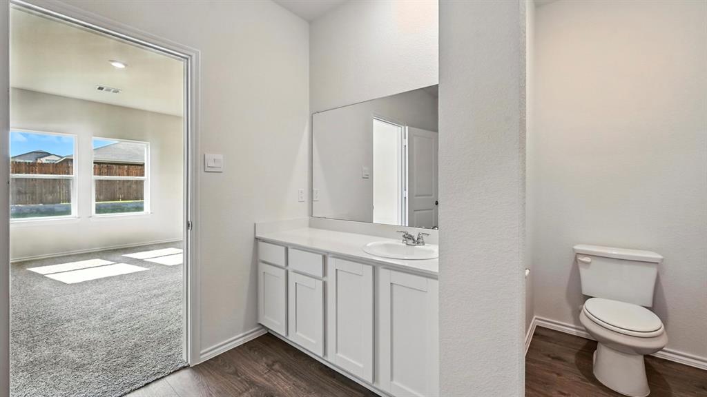 122 Pheasant Run Road Terrell, TX 75160 - Photo 6 of 36 Bathroom vanity area featuring white cabinetry, a single basin sink, and a large wall-mounted mirror