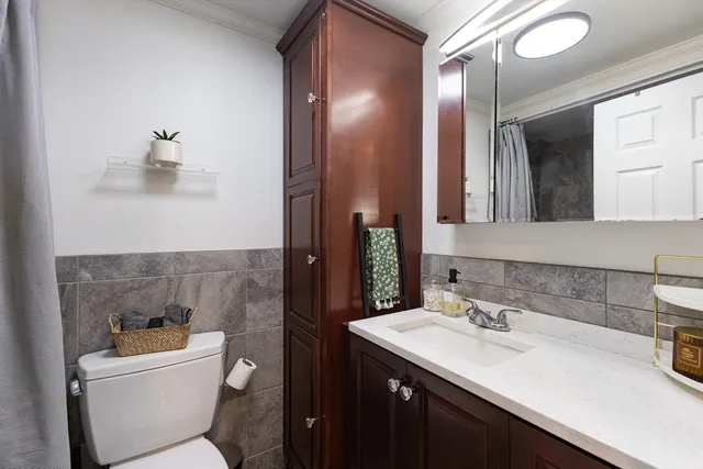 a bathroom with a sink and mirror with toilet