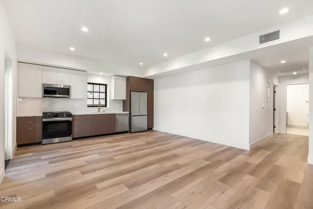 a view of a kitchen with a sink cabinets and stainless steel appliances