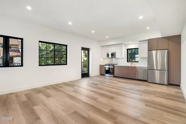 a view of a kitchen with refrigerator and windows