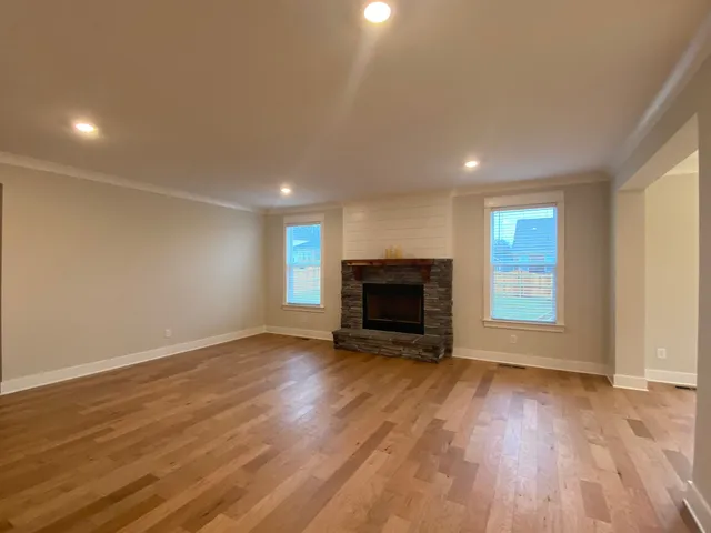 a view of empty room with wooden floor and fireplace
