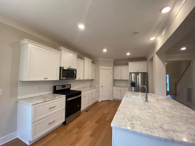 a large kitchen with kitchen island a sink stainless steel appliances and cabinets