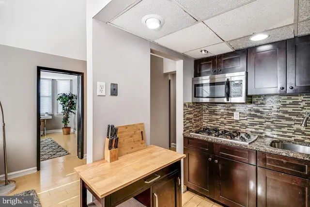 a kitchen with stainless steel appliances granite countertop a stove refrigerator and cabinets