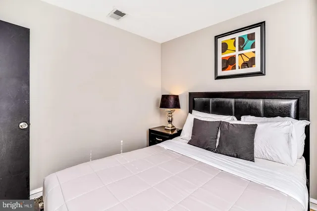 a bedroom with a bed and painting on the wall