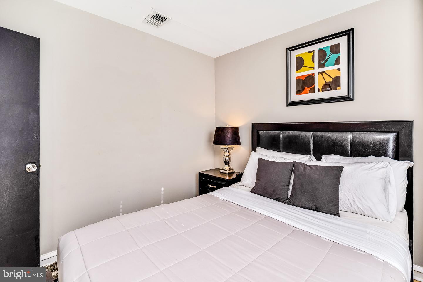 2135 Walnut Street, Unit 603 Philadelphia, PA 19103 - Photo 5 of 13 a bedroom with a bed and painting on the wall