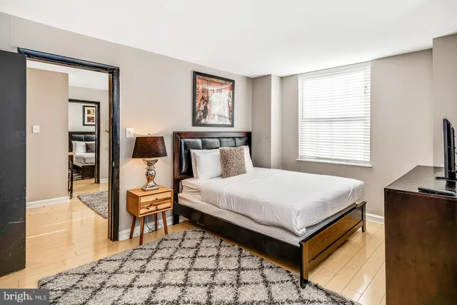a bedroom with a bed and wooden floor