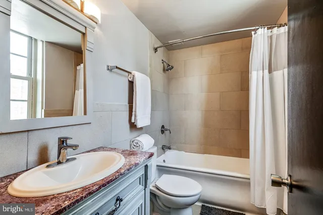 a bathroom with a granite countertop sink toilet and shower