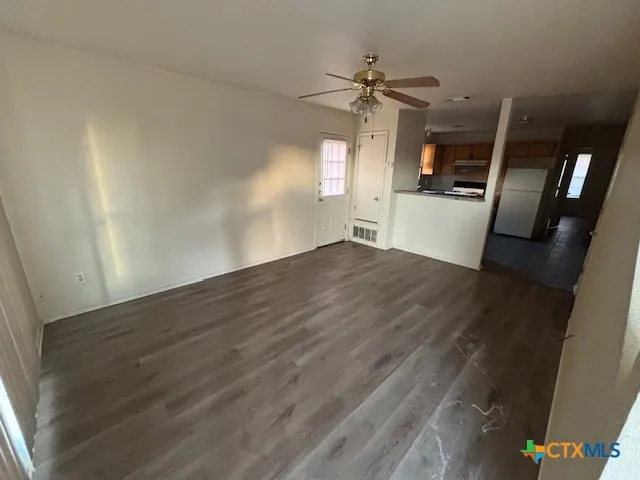 wooden floor in an empty room with a kitchen
