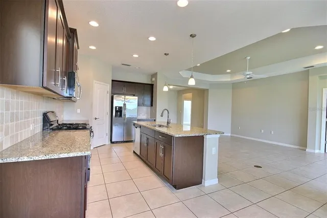 a kitchen with kitchen island granite countertop wooden cabinets and stainless steel appliances