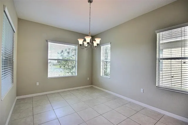 a view of an empty room and chandelier fan
