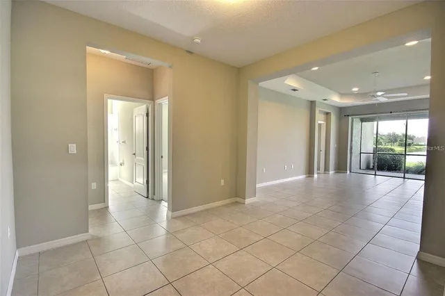 an empty room with a ceiling fan and window
