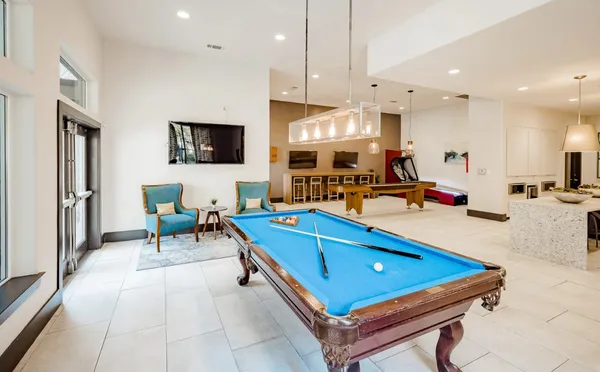 a living room with stainless steel appliances kitchen island a table and chairs in it