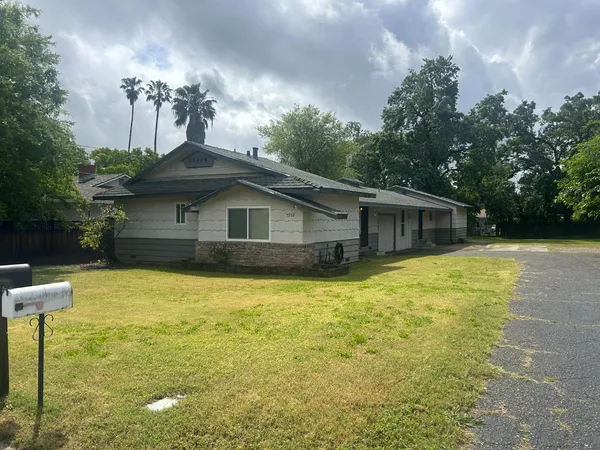a front view of house with yard and trees