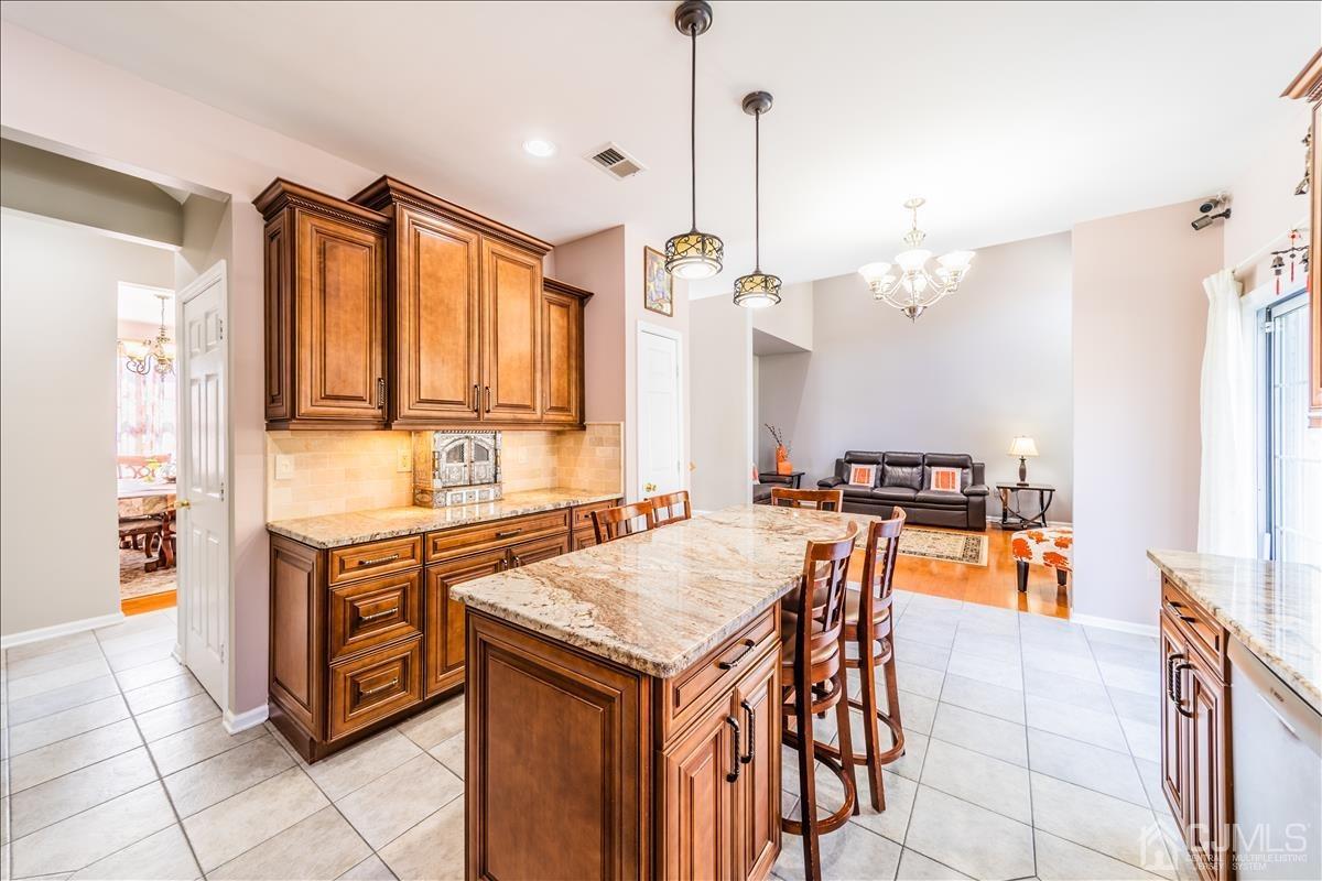 46 Potomac Road Monmouth Junction, NJ 08852 - Photo 20 of 42 a kitchen with stainless steel appliances granite countertop a stove a sink dishwasher and a refrigerator with wooden floor