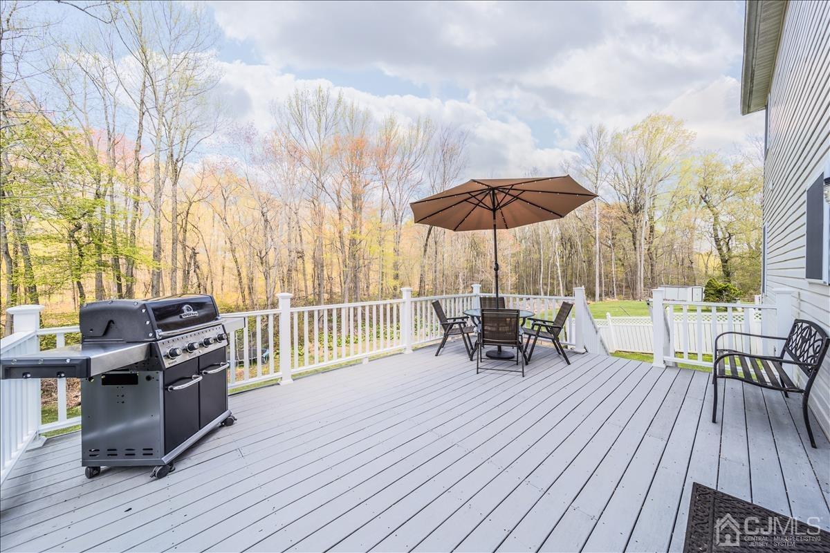 46 Potomac Road Monmouth Junction, NJ 08852 - Photo 38 of 42 a view of a roof deck with table and chairs under an umbrella with wooden floor