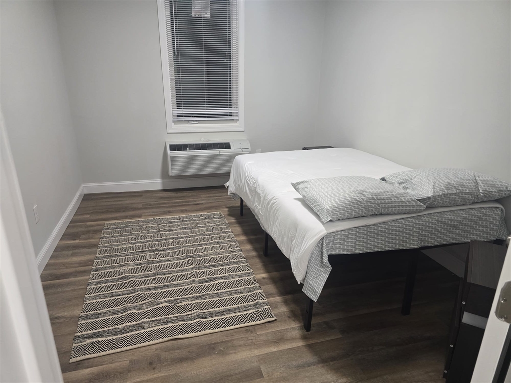 304 Warren Street, Unit 3L Boston, MA 02119 - Photo 3 of 9 a bedroom with a bed and dresser