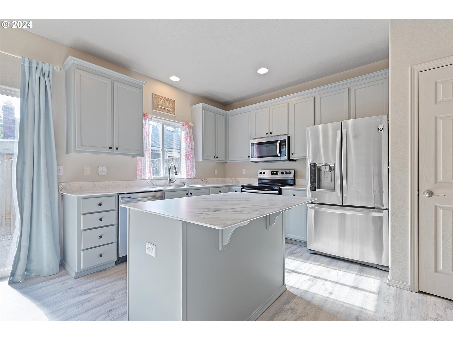 3181 Southwest 177th Place Beaverton, OR 97003 - Photo 5 of 31 a kitchen with kitchen island a sink stainless steel appliances and cabinets