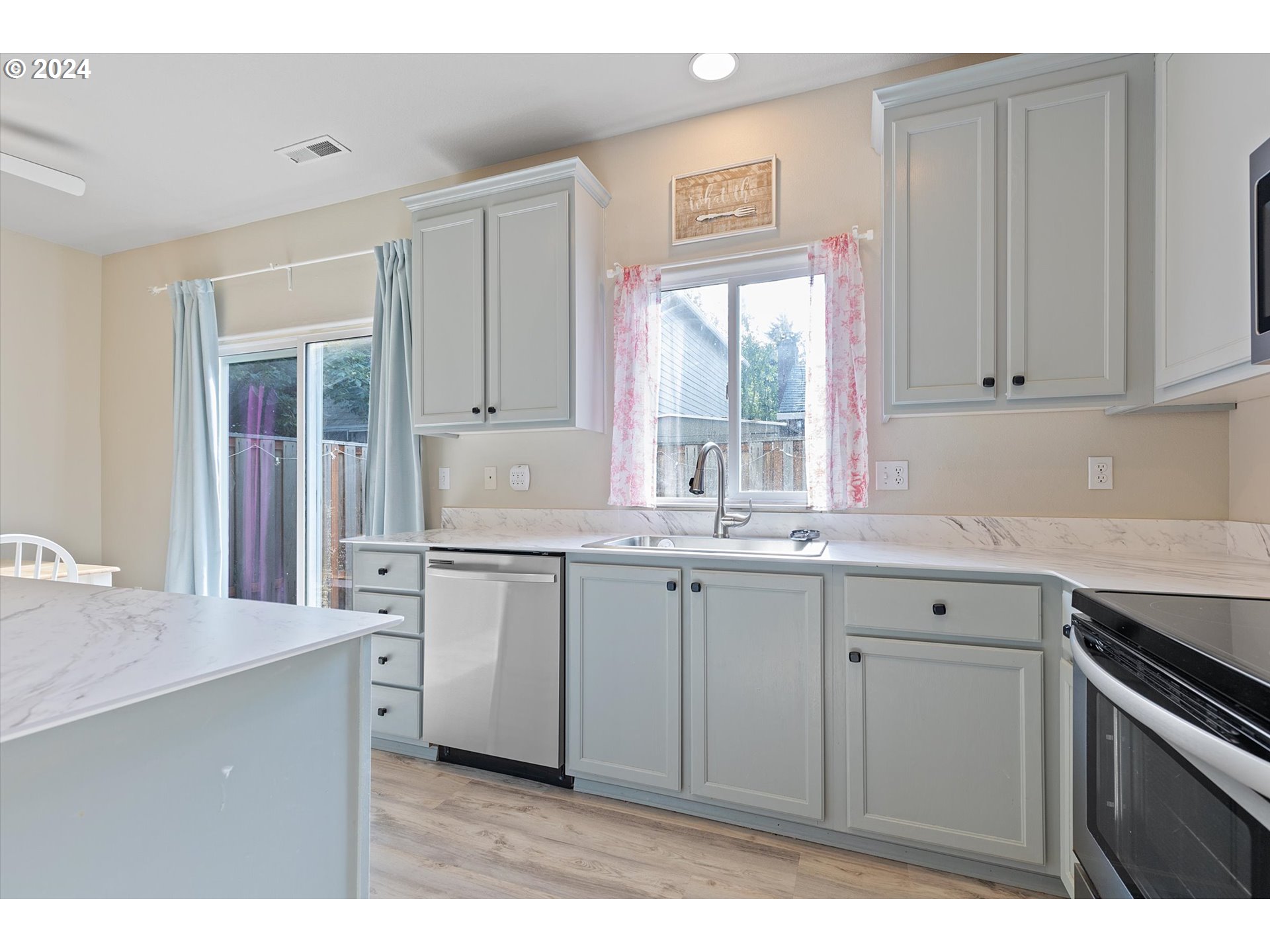 3181 Southwest 177th Place Beaverton, OR 97003 - Photo 6 of 31 a kitchen with granite countertop white cabinets and white appliances