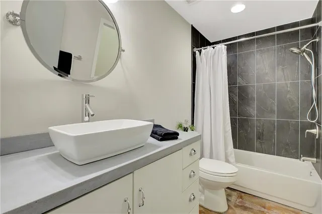 a bathroom with a tub shower and sink