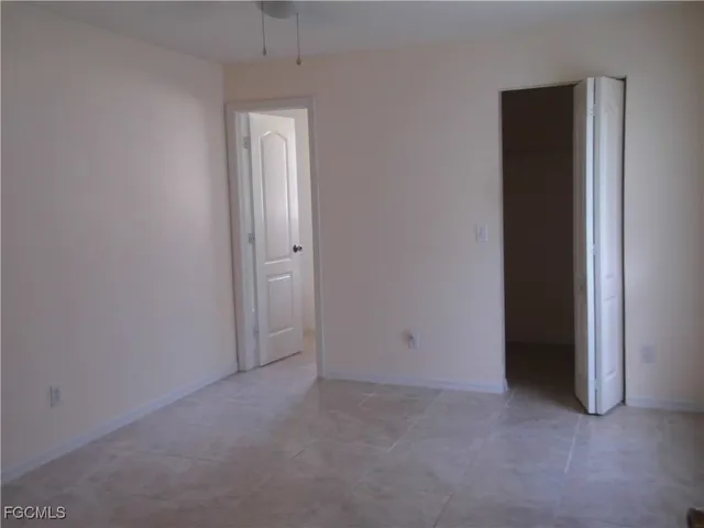 an empty room with closet and a hallway