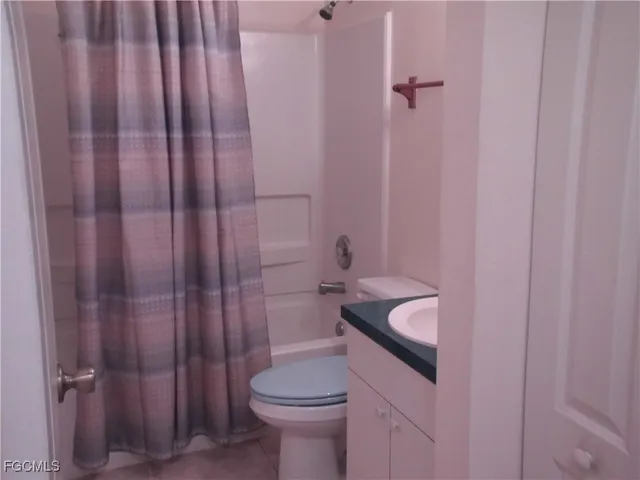 a bathroom with a granite countertop toilet and a sink