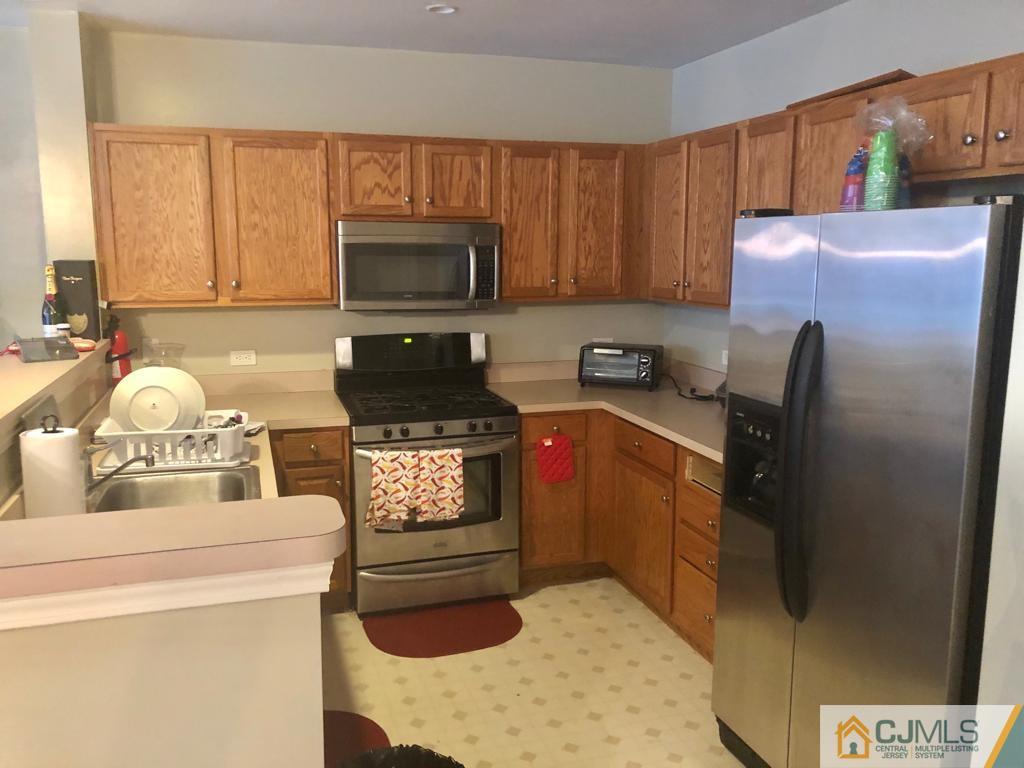 368 Rector Street, Unit 404 Perth Amboy, NJ 08861 - Photo 9 of 11 a kitchen with a sink a stove and a microwave