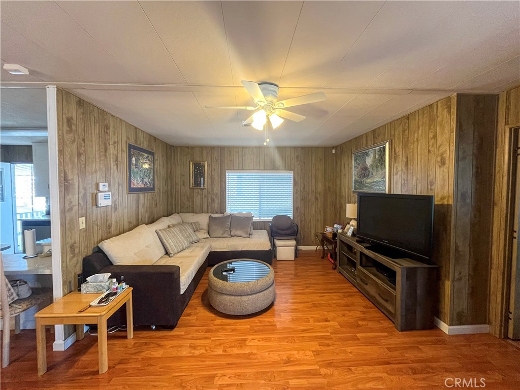 a living room with furniture a flat screen tv and kitchen view