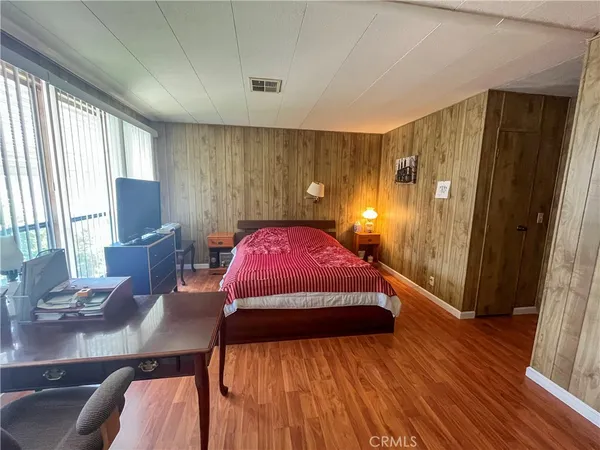 a bedroom with a bed window and wooden floor