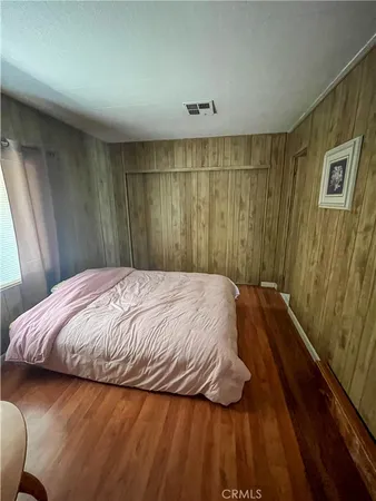 a bed sitting in a spacious bedroom next to a window