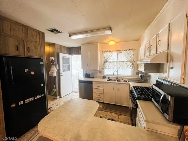 a kitchen with a sink stove top oven and refrigerator