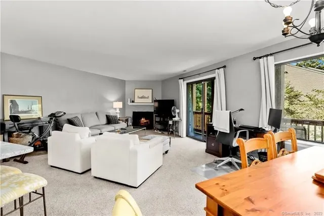 a living room with furniture a large window and flat screen tv