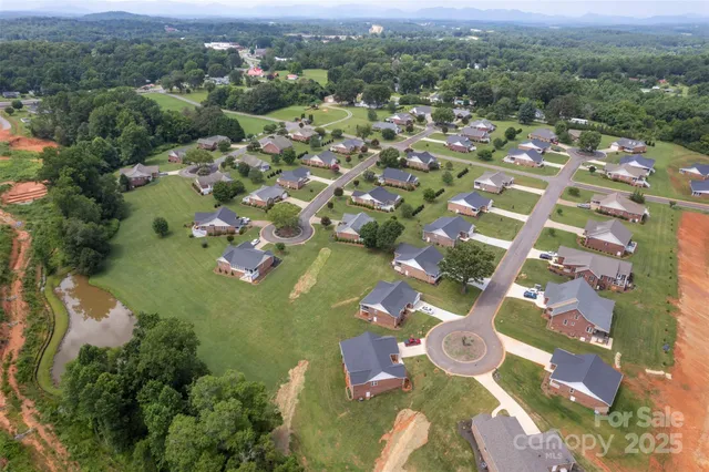 an aerial view of a house with a garden and lake view