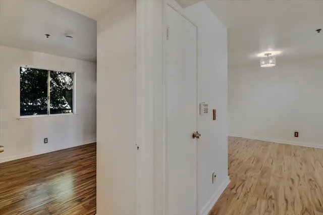 a view of a kitchen with wooden floor and a refrigerator