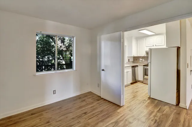 a view of a hallway with wooden floor and closet area