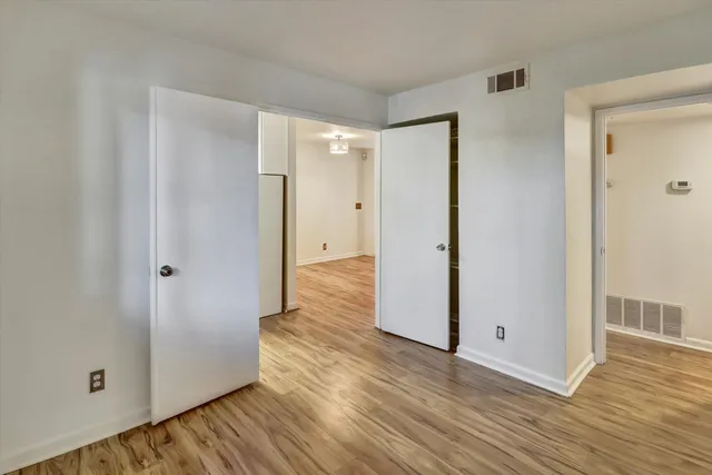 a view of an empty room with wooden floor