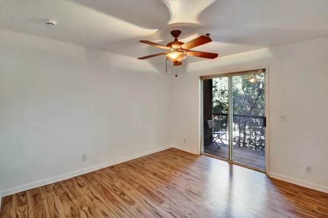 a view of a livingroom with wooden floor and a ceiling fan