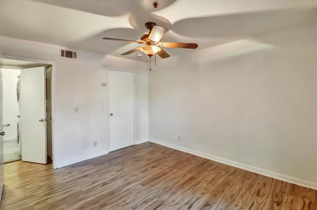wooden floor in an empty room with a fan