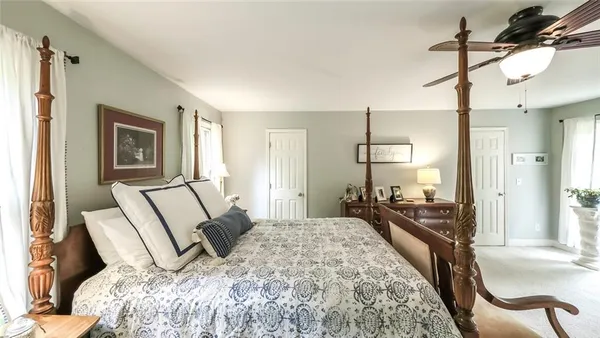 a spacious bedroom with a bed a table and chair
