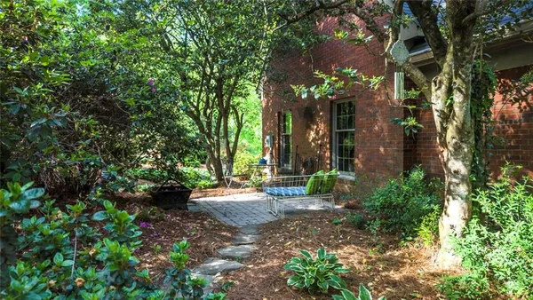 an aerial view of residential house with outdoor space and trees all around