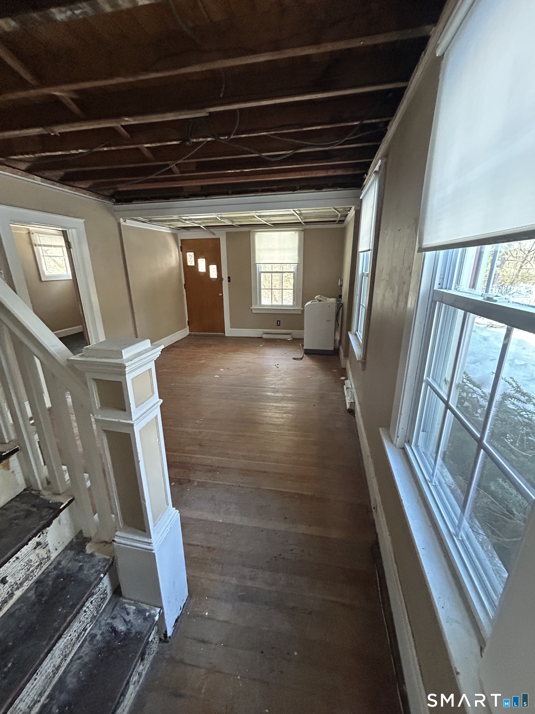 69 Munson Road Wolcott, CT 06716 - Photo 8 of 20 a view of an empty room with wooden floor and stairs