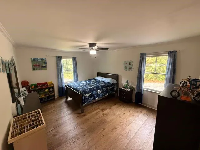 a bedroom with a bed and a large window