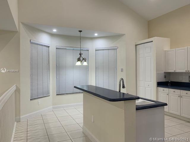 Silver Shores Miramar, FL 33027 - Photo 20 of 21 a kitchen with kitchen island granite countertop a sink and a refrigerator